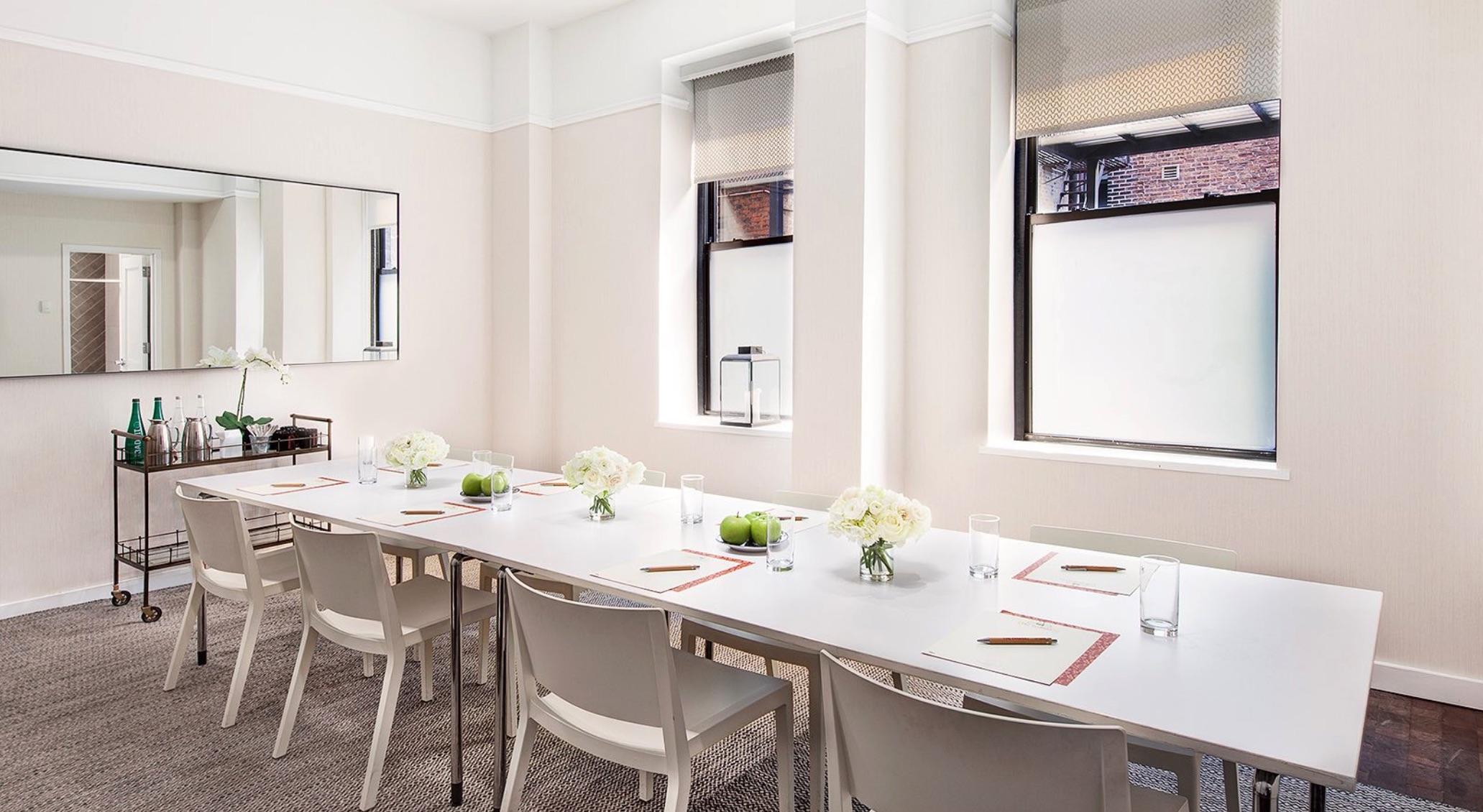 طاولة غرفة اجتماعات بيضاء وكراسي في Redbury New York