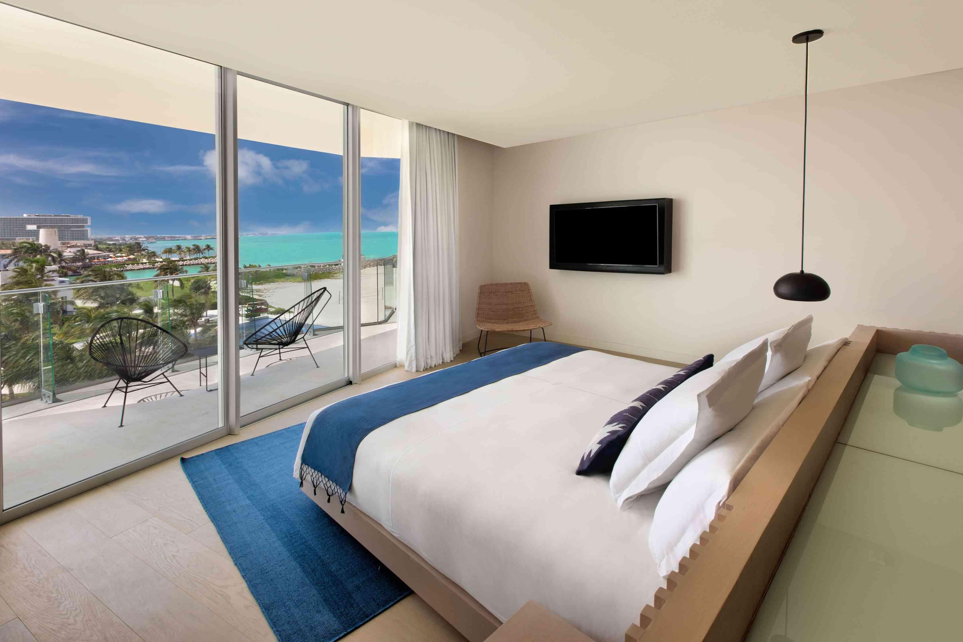 غرفة نوم مع سرير مواجه للشرفة المطلة على المحيط
