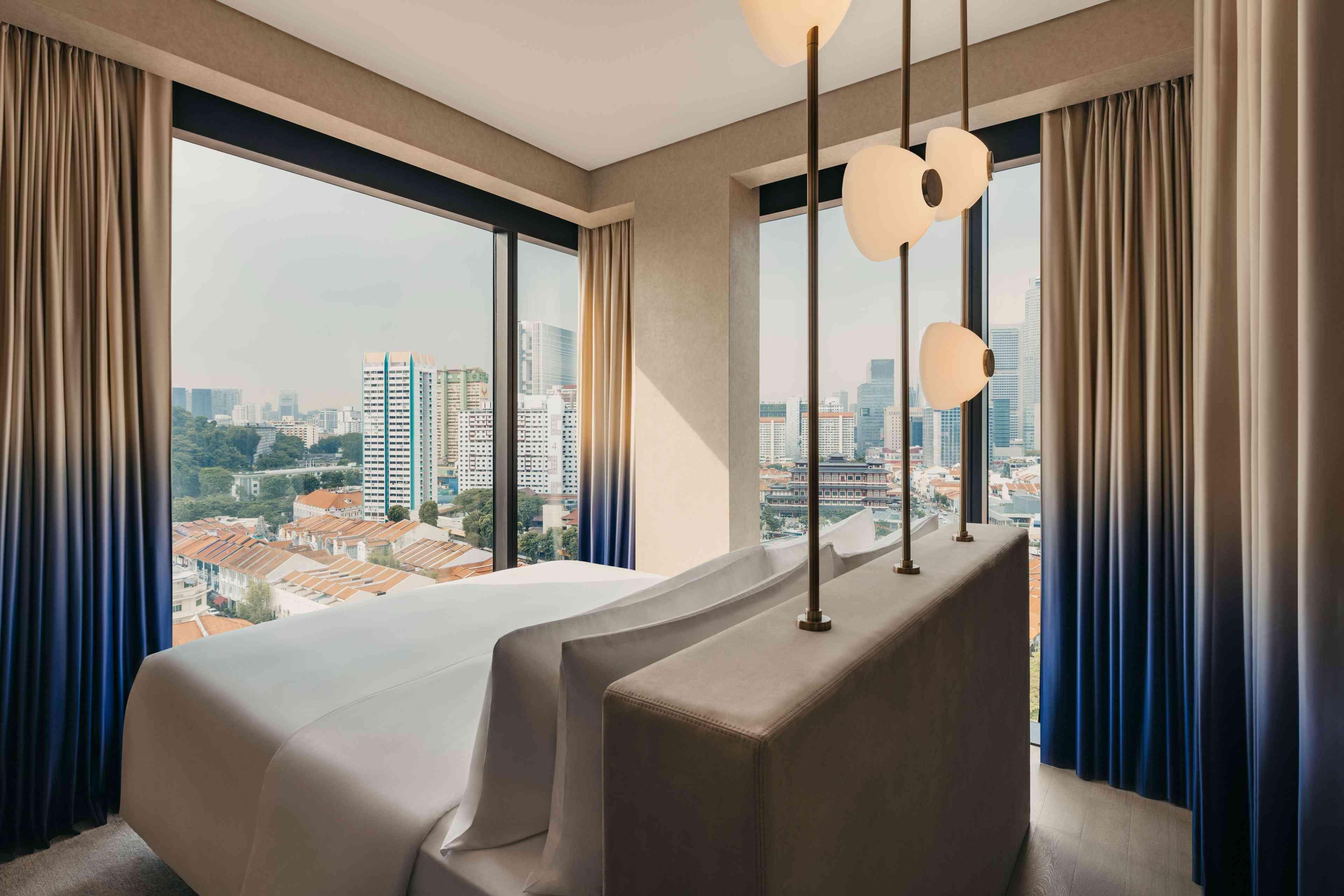 جناح في Mondrian Singapore Duxton به نوافذ ممتدة من الأرض حتى السقف تطل على المدينة. 