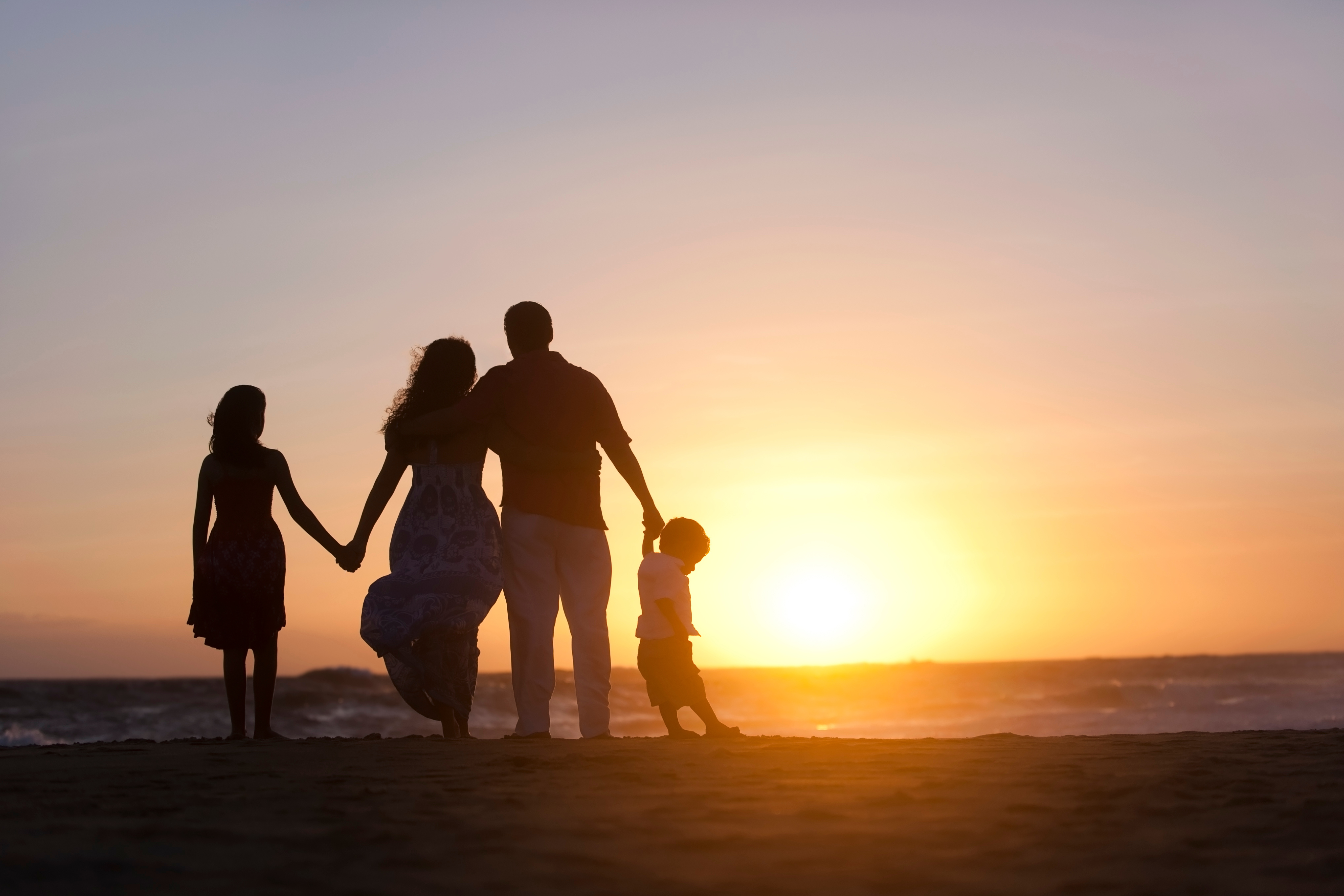 عائلة على الشاطئ أثناء غروب الشمس